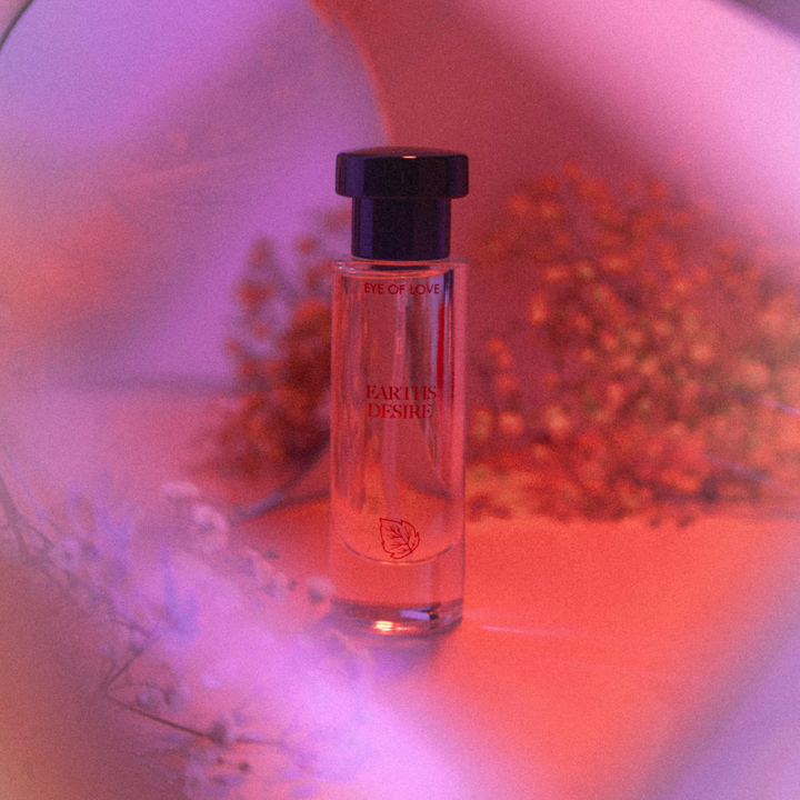 Eye of Love pheromone perfume - Earth's Desire from the Bloom collection against a neon pink backdrop