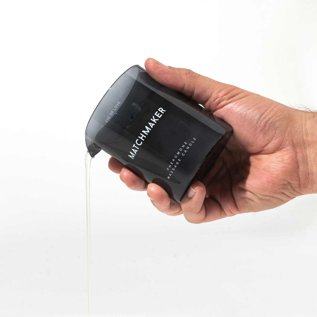Hand pouring Eye of Love's Matchmaker Black Diamond Massage Candle melted wax