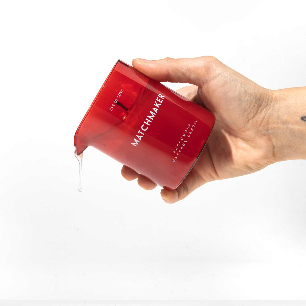 Hand pouring Eye of Love's Matchmaker Red Diamond pheromone massage candle wax